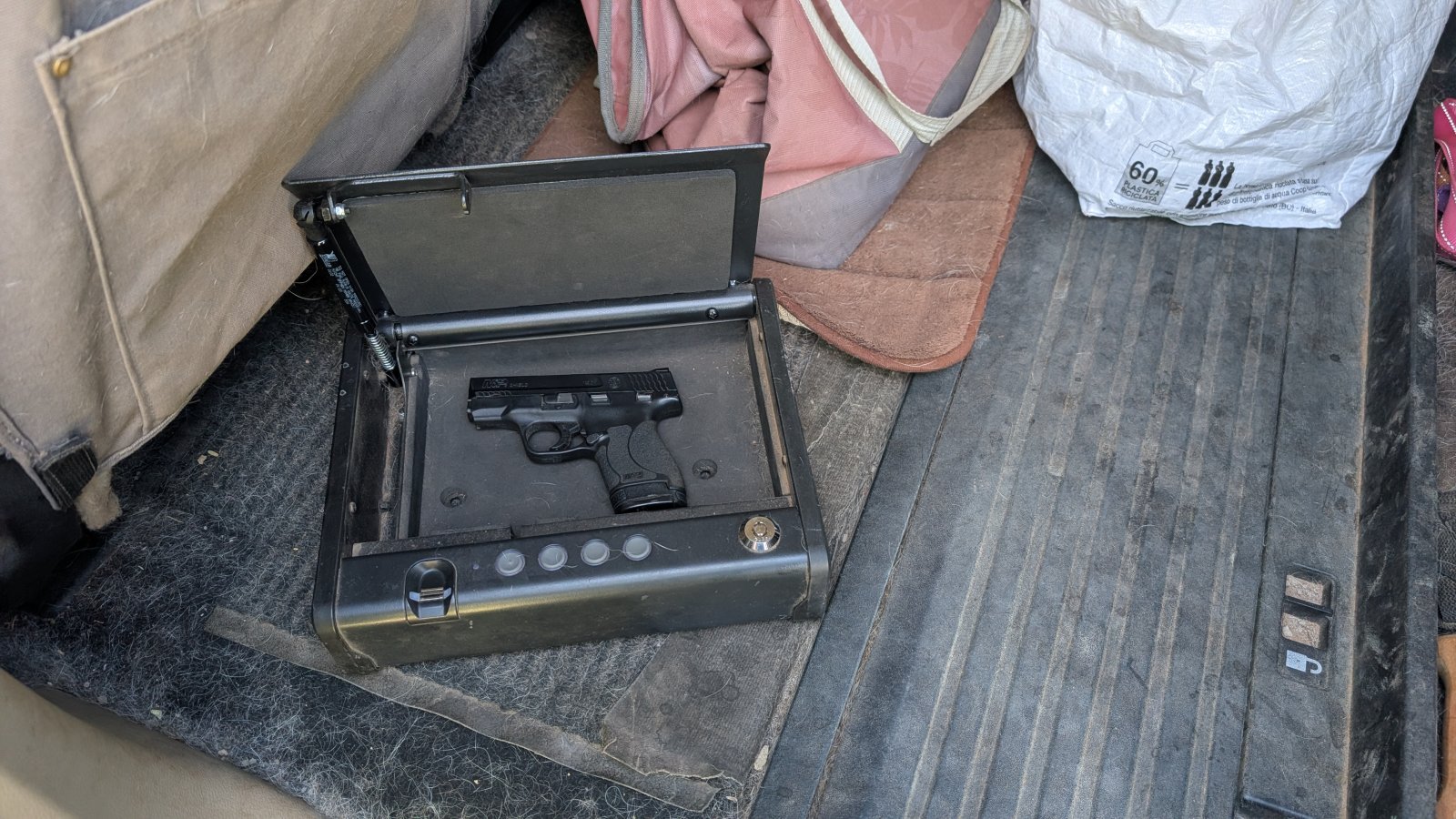 Smith & Wesson M&P Shield pistol nested securely inside a locked biometric vehicle safe